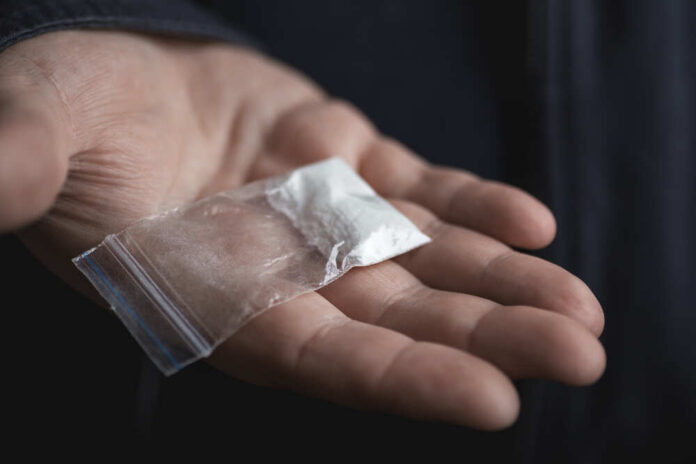 Mans,Hand,Holding,On,Palm,Plastic,Packet,With,Cocaine,Powder