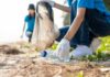 People collecting plastic waste on sandy beach