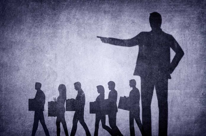 shutterstock_2254036017.jpg featured image Shadows of laid-off workers walking, large figure pointing.