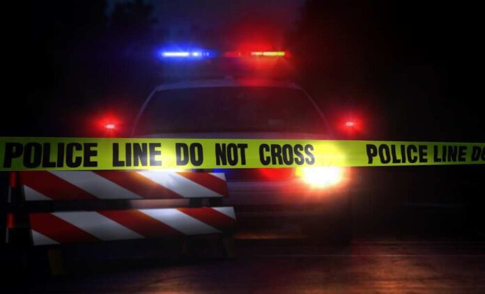 shutterstock_693454099.jpg featured image Police car with flashing lights behind caution tape.