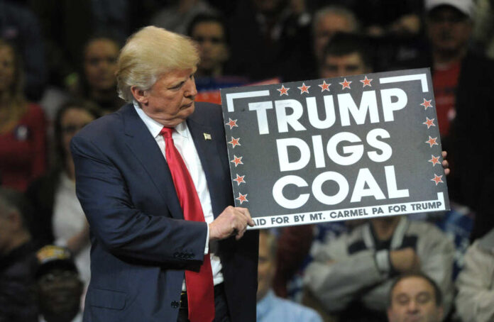 shutterstock_1427778647.jpg featured image Donald Trump holding sign saying Trump Digs Coal