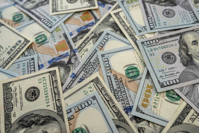 shutterstock_1912026715.jpg featured image Scattered hundred dollar bills with Benjamin Franklin's portrait.