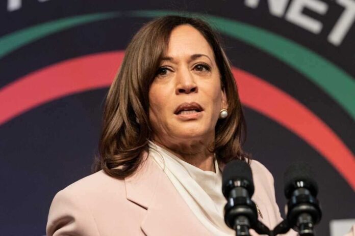 shutterstock_2289228675-1.jpg featured image Kamala Harris speaking at an event, microphones in front.