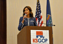 Kristi Noem speaking at KS GOP event podium.