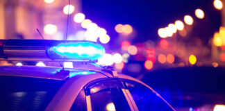 Police car with blue lights flashing at night.