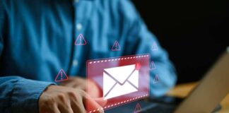 Person typing on laptop with mail warning icons.