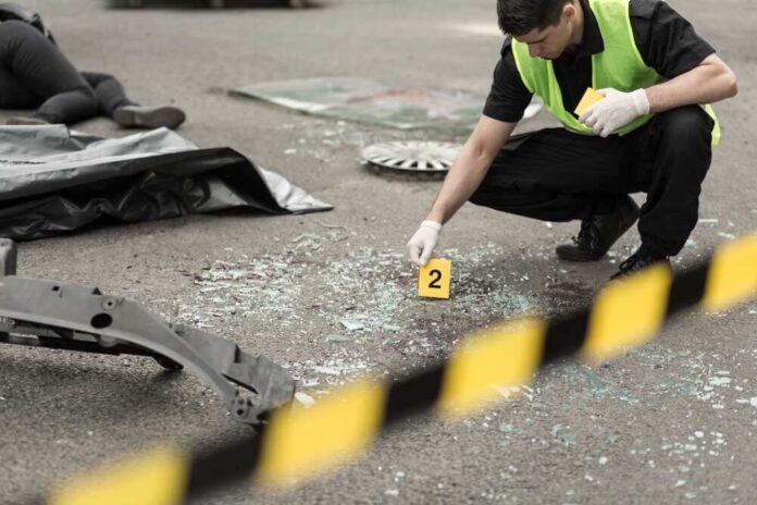 shutterstock_301329224.jpg featured image Police investigating crime scene with evidence marker and body bag.