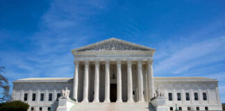 U.S. Supreme Court building under clear blue sky.