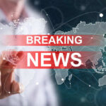 Breaking news graphic over world map background.