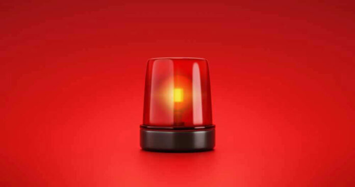 shutterstock_2053758056-1.jpg Red emergency light on solid red background.