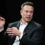 Elon Musk in a suit talking