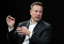 Elon Musk in a suit talking