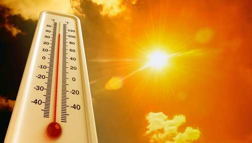 Thermometer displaying high temperature against a bright sun