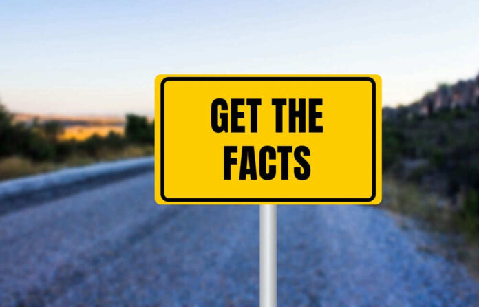 shutterstock_2512615135.jpg Yellow sign reads Get the Facts on road