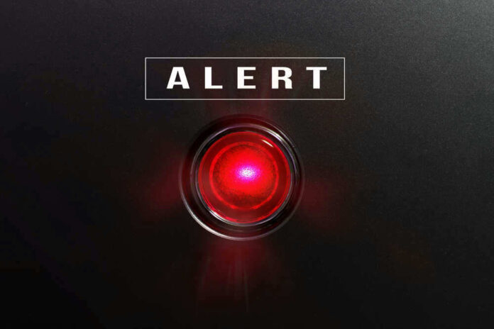 shutterstock_582441490.jpg Red alert light against black background text ALERT
