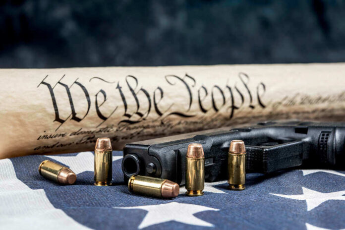Gun, bullets, Constitution scroll on American flag