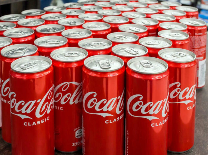 Coca-Cola cans stacked on a surface.