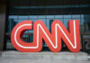 Red CNN logo in front of glass building