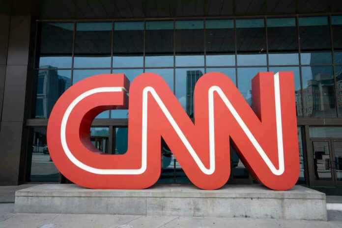Red CNN logo in front of glass building