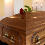 Record-Breaking American Athlete Passes Away A wooden casket with a red rose placed on top