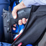 VIDEO: Teen Shooter Unleashes Nine Minutes of Terror A hand holding a gun inside a backpack