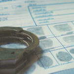 Celebrity Chef’s Bank Robbery Rampage Handcuffs on a fingerprint document.
