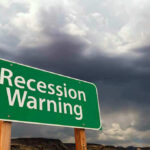 Recession Warning sign with dark, stormy clouds above.