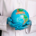 Globalist Health Plan FAILS — Sovereignty Attacked A medical professional holding a globe with a bandage on it