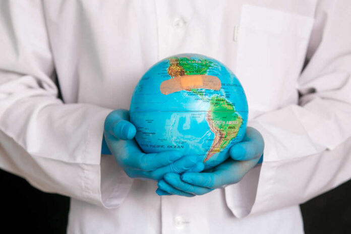 A medical professional holding a globe with a bandage on it