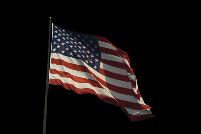 American flag waving against a black background.