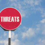 Cartel Threat ROCKS Press — Journalist Found With Chilling Note Red sign with the word threats against sky