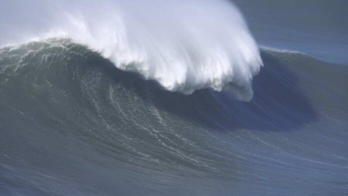 Large foamy wave rolling on the surface of a stormy ocean
