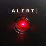 Beloved American Institution DIES Red alert light against black background, text ALERT.