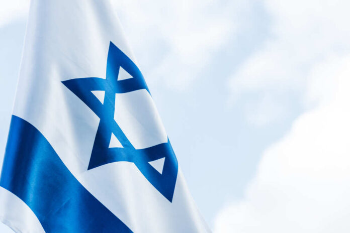 Close-up of the Israeli flag waving against a cloudy sky