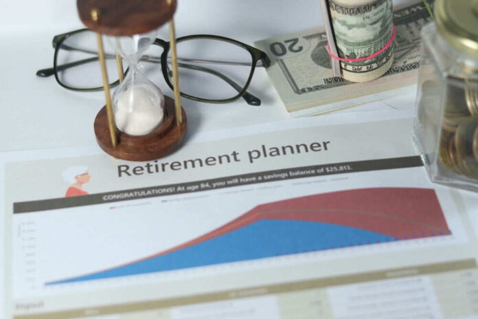 shutterstock_2485751417.jpg Retirement planner graph with money glasses hourglass