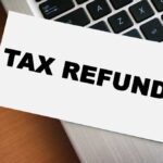 A card displaying the words 'TAX REFUND' placed on a laptop keyboard
