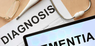 Medical diagnosis paperwork and a tablet displaying the word Dementia