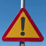 Triangular warning sign with exclamation mark.