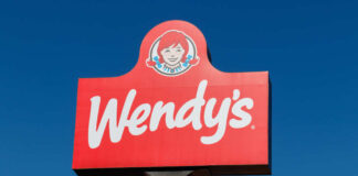 Wendy's restaurant sign against a clear blue sky