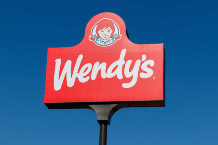 Wendy's restaurant sign against a clear blue sky