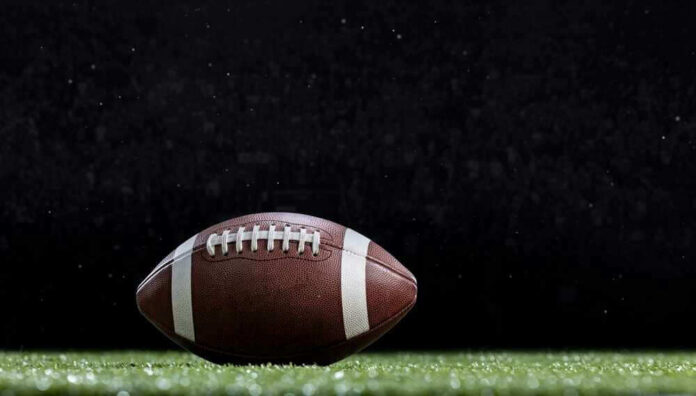 Close-up of a football on a grassy field.