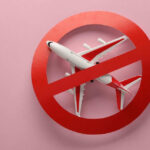 Americans TRAPPED as Airlines Halt All Flights Airplane inside red prohibition sign on pink background.
