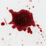 Red liquid splatter on a white background.