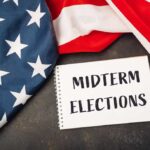 American flag and a notebook with 'MIDTERM ELECTIONS' written on it