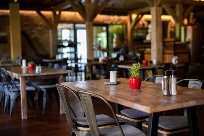 Interior of a cozy restaurant with wooden tables and decorative plants