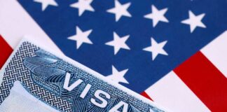 Close-up of a US visa on a background of the American flag
