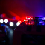 Four Slain in Street Before Suspect Is Shot Dead Police car lights shining in the dark.