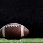 Close-up of a football on a grassy field.