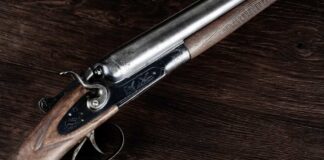 Close-up of an antique shotgun with a wooden stock and metal barrel