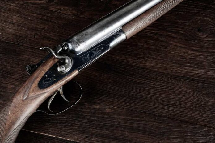 Close-up of an antique shotgun with a wooden stock and metal barrel